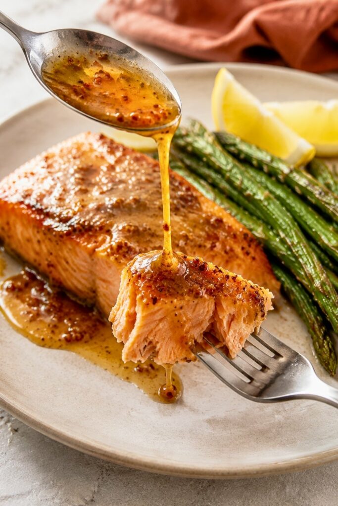 Honey Mustard Baked Salmon on a plate with asparagus and lemon