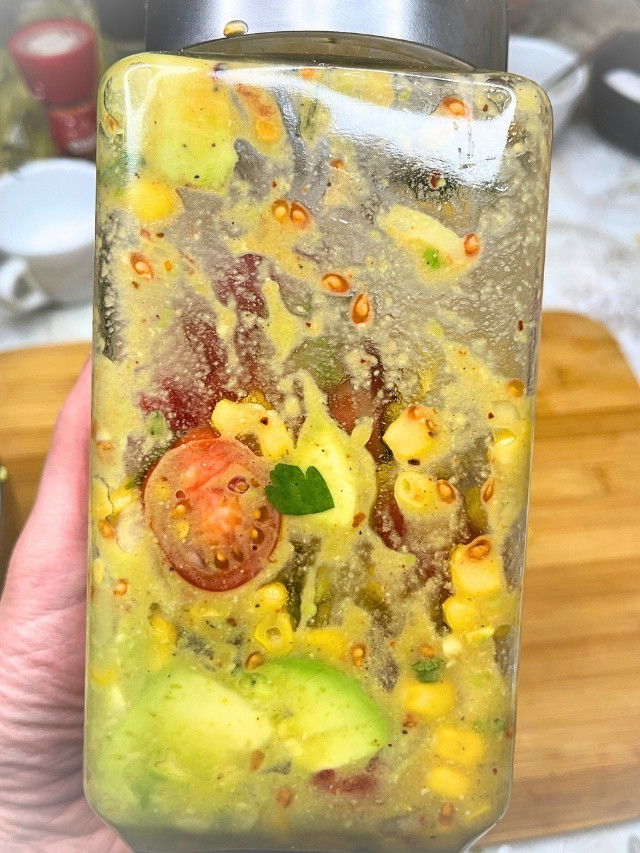 Colorful jar of mixed salsa ingredients